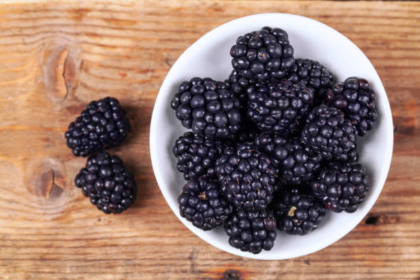 Blackberries with leaves on wooden rustic table