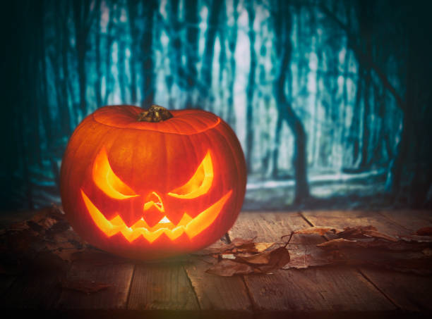 istock Pumpkin Burning In A Spooky Forest At Night - Halloween Background 1176437326