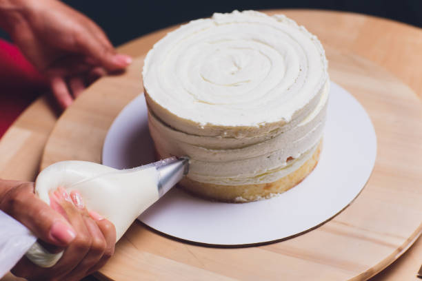 istock women's hands making biscuit cake with white cream using a cooking spatula. 1176439819