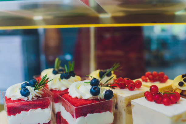 istock Close up of vendor's hands taking out cake from showcase in bakery. 1176439892