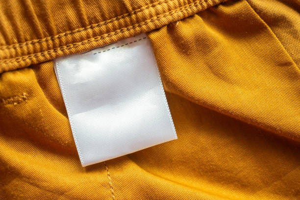 istock White blank clothing tag label on brown cotton shorts fabric texture background 1176440185