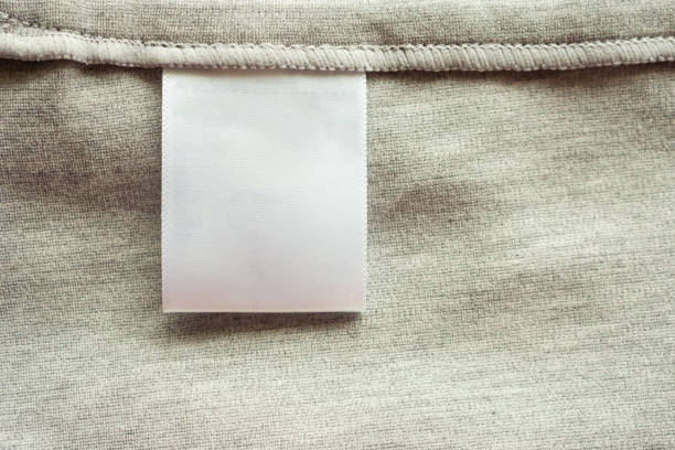 White blank laundry care clothing label on gray fabric texture background