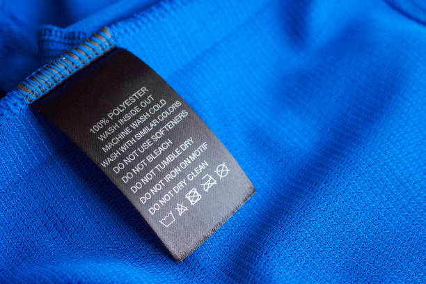 roupa preta de lavagem do cuidado de lavanderia etiqueta da roupa na camisa azul do esporte do poliéster de jersey - label textile shirt stitch - fotografias e filmes do acervo