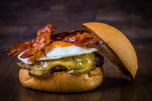 istock Craft beef burger with cheese, egg, bacon and pickles on wood table and rustic background 1176443843