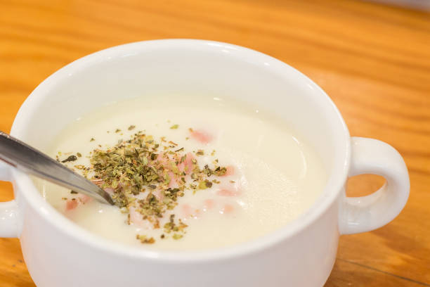 Ham soup in a white bowl on a wooden table