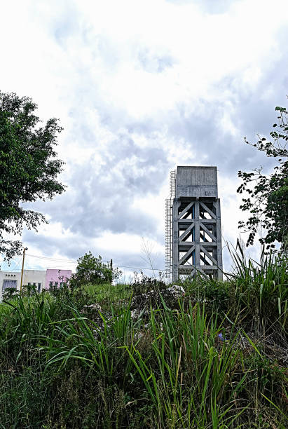 istock cement water tower, in grassy meadow and green vegetation 1176449619