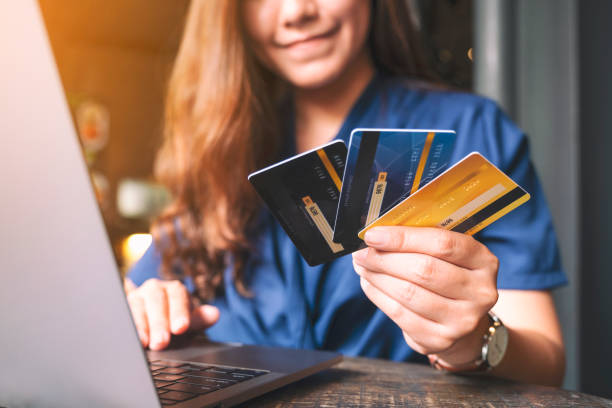 istock a business woman holding credit cards while using laptop computer 1176455138
