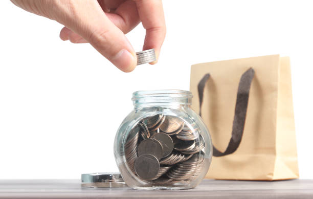 istock Dropping Coins into Glass Jar Labeled Retirement 1176458961