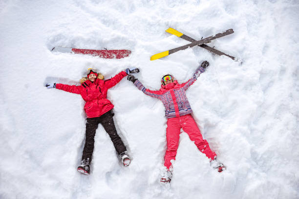 Aerial photo of skier and snowboarder lying on snow Skier and snowboarder are lying on snow with ski and snowboard and having fun. Aerial photo top of ski mountain stock pictures, royalty-free photos & images