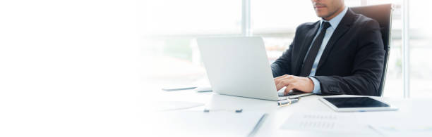 Concentrated Businessman is working on Laptop computer.