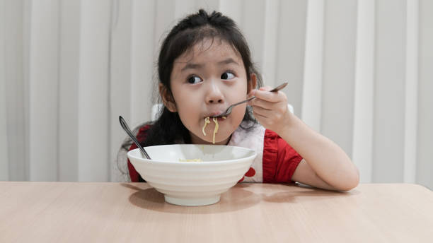 istock Asian little cute girl enjoy eating noodle 1176461663