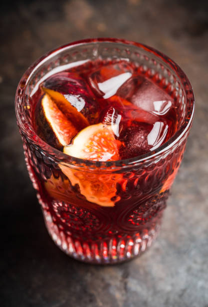 Old-fashioned cocktail with figs on the rustic background