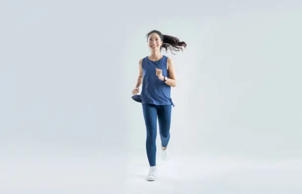 Photo of Asian woman run marathon studio white background.