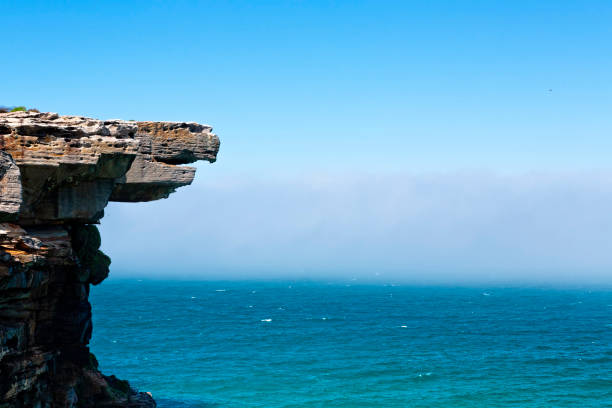 Eagle rock with a dense sea fog off shore  Australia Eagle Rock and a dense sea fog that hovered off shore all morning and would sometimes blow back in. eagle rock stock pictures, royalty-free photos & images