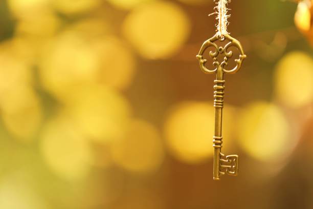istock Key on yellow bokeh background. Vintage copper key 1176468917