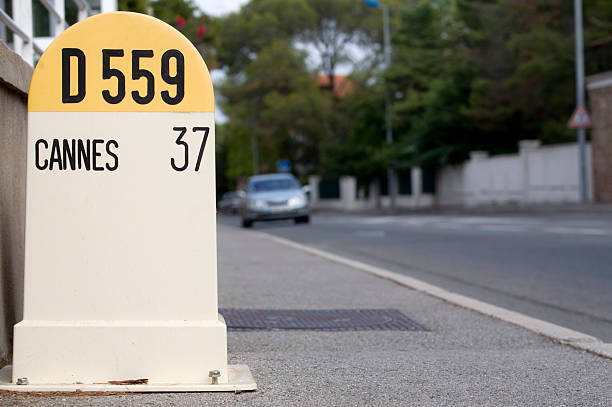 car passing a distance sign to Cannes  distance sign stock pictures, royalty-free photos & images