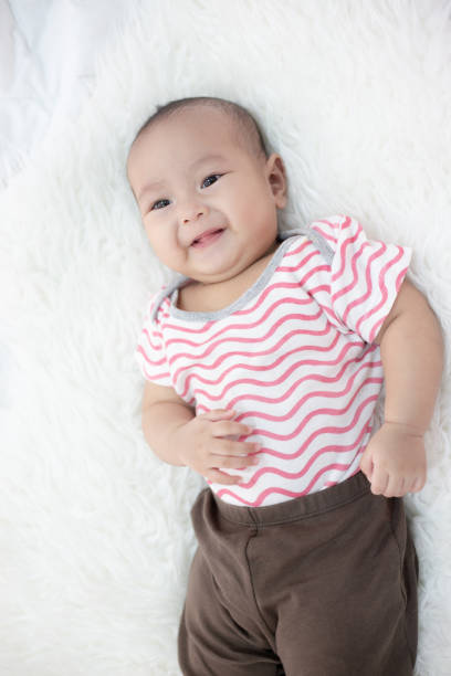 istock happy baby lying on white bed 1176471089