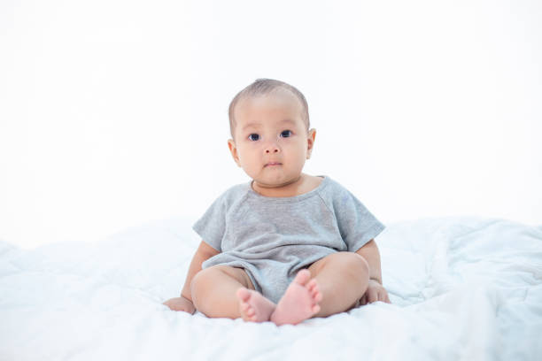 The little boy sitting on the bed