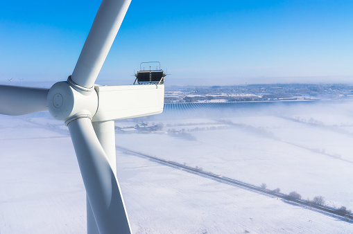 Wind turbine in winter with snow and fog Aerial view and close-up view