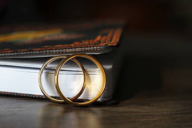 istock Two gold wedding rings and a paper notebook, wooden table 1176472540