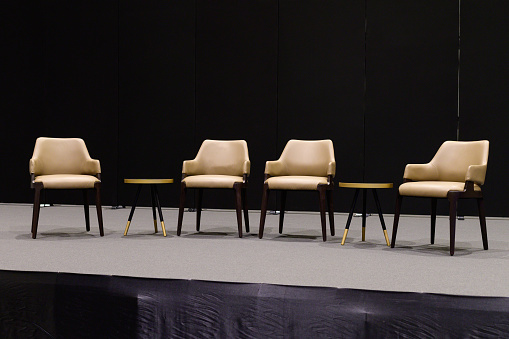 Empty chairs on stage ready for seminar.