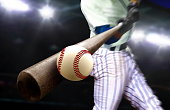 istock Baseball player hitting ball with bat in close up under stadium spotlights 1176475684