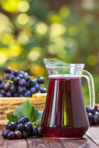 istock grape juice in glass jug 1176476618