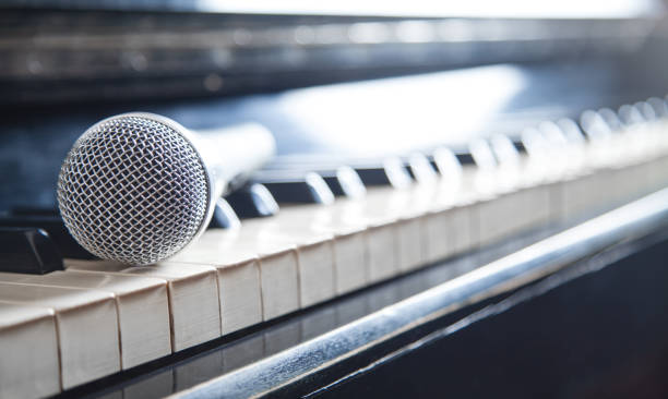 istock Microphone on piano keyboard. White and black. Music 1176477692