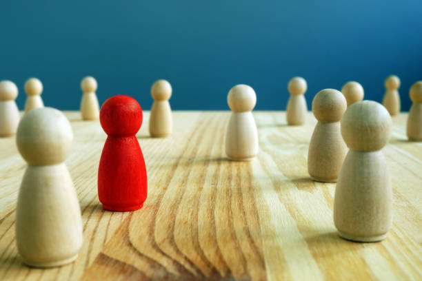 istock Inclusion social concept. Red figurine between wooden figurines. 1176478773
