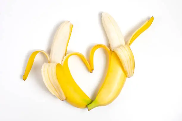 Photo of Two peeled bananas arranged together in shape of heart representing couple in love