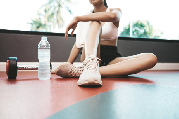 istock Women sit back and relax after exercise. There is a water bottle and dumbbells,selective focus 1176482931