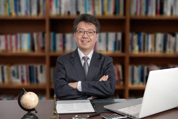 A portrait of an Asian middle-aged male businessman sitting at a desk. stock photo