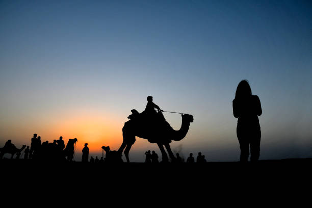 istock Camel Rides in silhouette, SAM dunes, Jaisalmer, Rajasthan, India 1176484145
