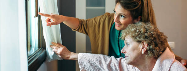 istock Caregiver showing the view through the window to elderly patient 1176484184