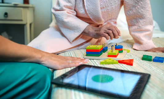 Doctora femenina mostrando formas geométricas a pacientes de edad avanzada photo