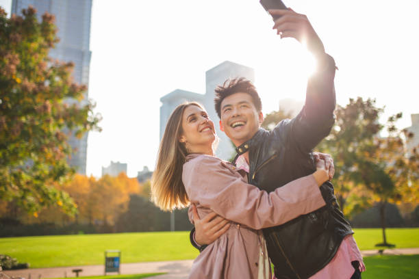 istock Multi-ethnic couple taking selfie in public park 1176486962
