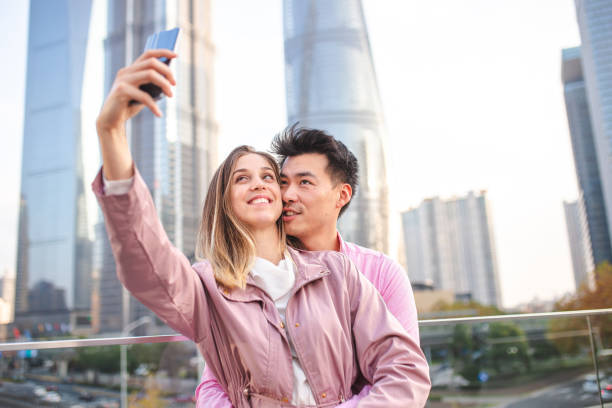 istock Embracing couple making selfie with phone on rooftop 1176487067