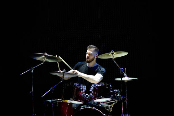 istock Silhouette drummer on stage. Dark background, smoke spotlights 1176487317