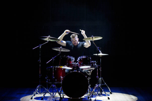 istock Silhouette drummer on stage. Dark background, smoke spotlights 1176487426