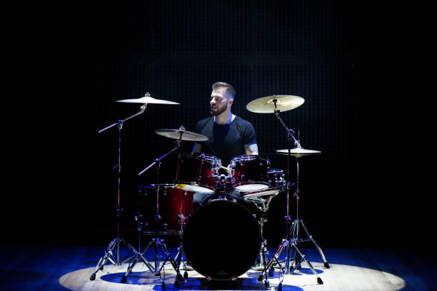 istock Silhouette drummer on stage. Dark background, smoke spotlights 1176487450