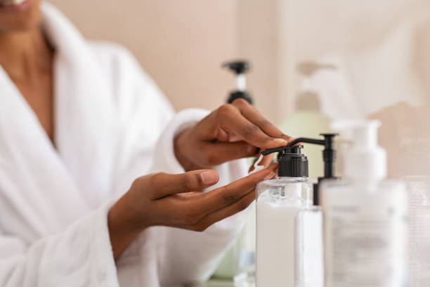 femme prenant la crème hydratante de corps du distributeur - article de toilette photos et images de collection