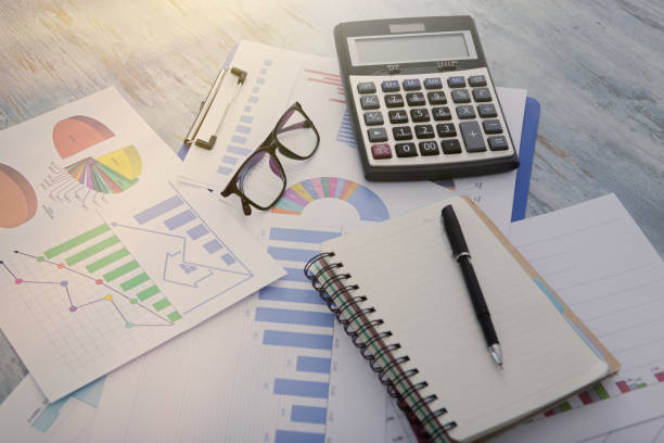 istock graphs calculator and glasses on the table. business concept 1176488333