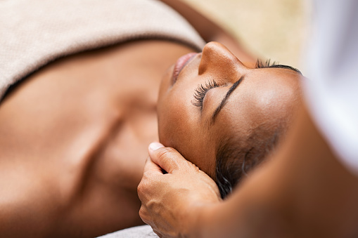 Mujer negra recibiendo masaje de cabeza photo