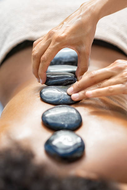 masaje con piedras calientes en el spa - lastone therapy pampering spa treatment women fotografías e imágenes de stock