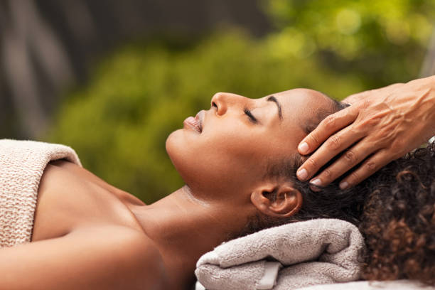 bella donna africana rilassante con massaggio viso - massaging facial massage beautician beauty treatment foto e immagini stock