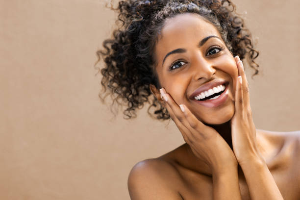 Surprised beautiful black woman Beautiful young woman smiling after fantastic face treatment . Happy beauty african girl with curly hair and toothy smile excited after spa treatment isolated on background with copy space. Surpise and astonishment beauty concept. black skin stock pictures, royalty-free photos & images