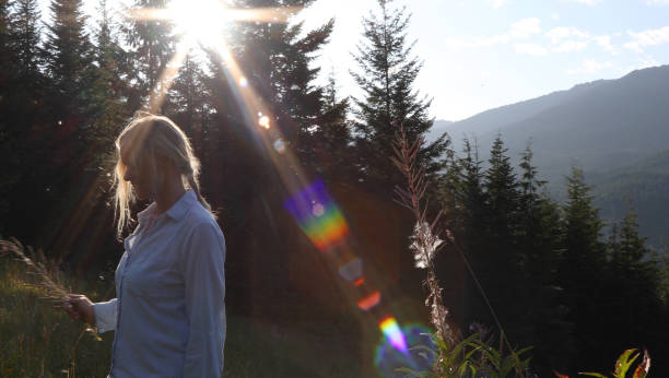 istock Woman walks through grassy meadow at sunrise 1176493356