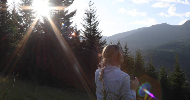 istock Woman walks through grassy meadow at sunrise 1176493961