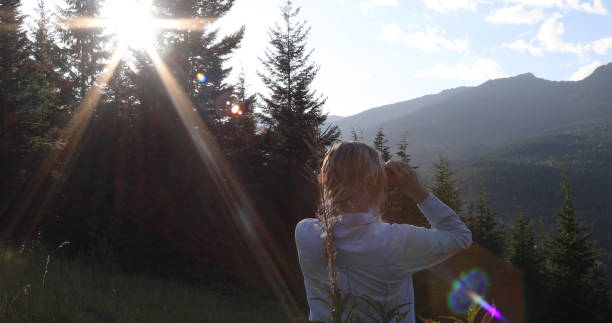 istock Woman walks through grassy meadow at sunrise 1176493962