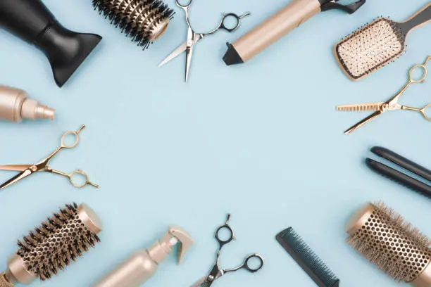 Photo of Hair cutting tools and accessories on blue background with space